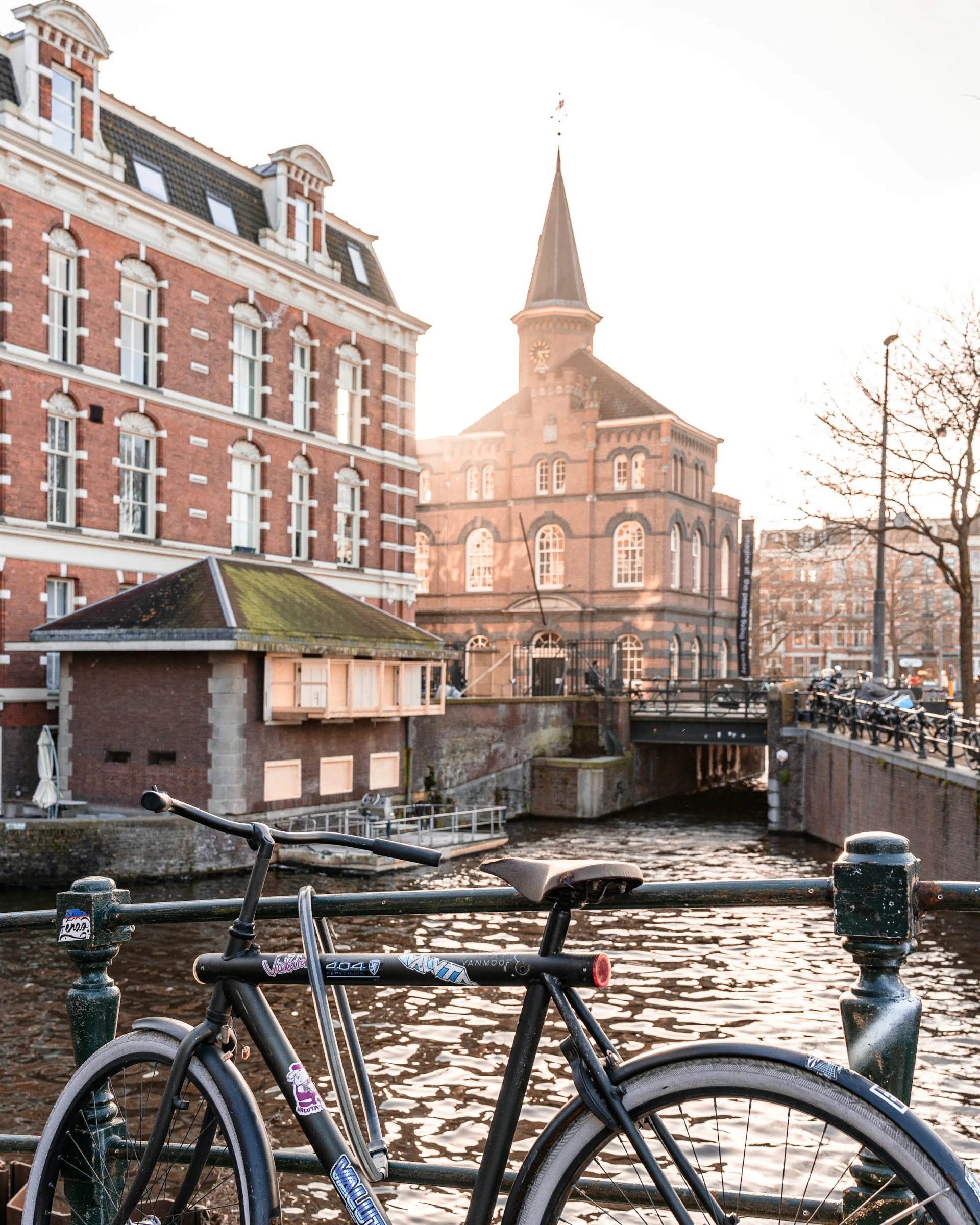 Bicycles parked beside a canal house at golden hour