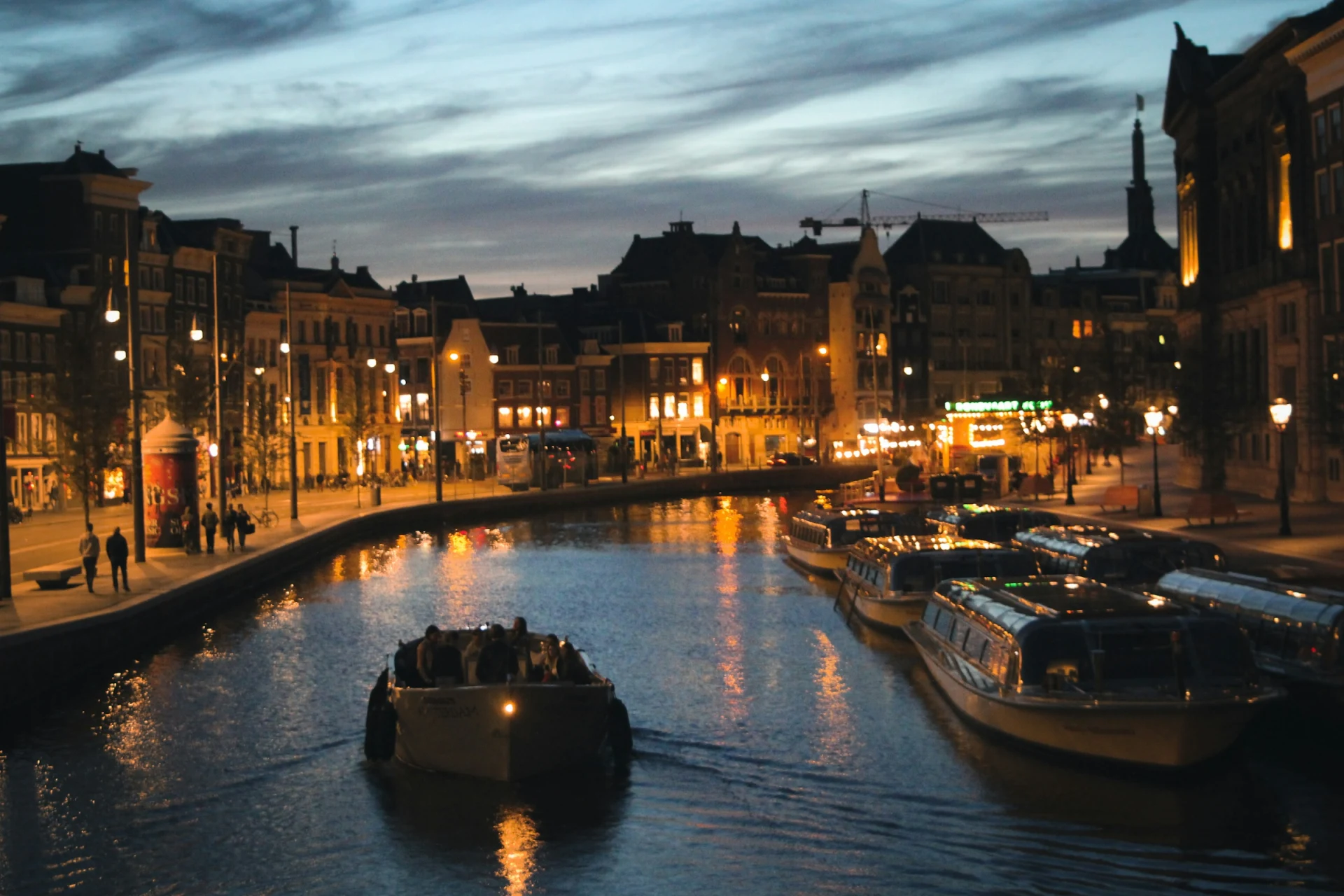 An illuminated bridge over an Amsterdam canal at night