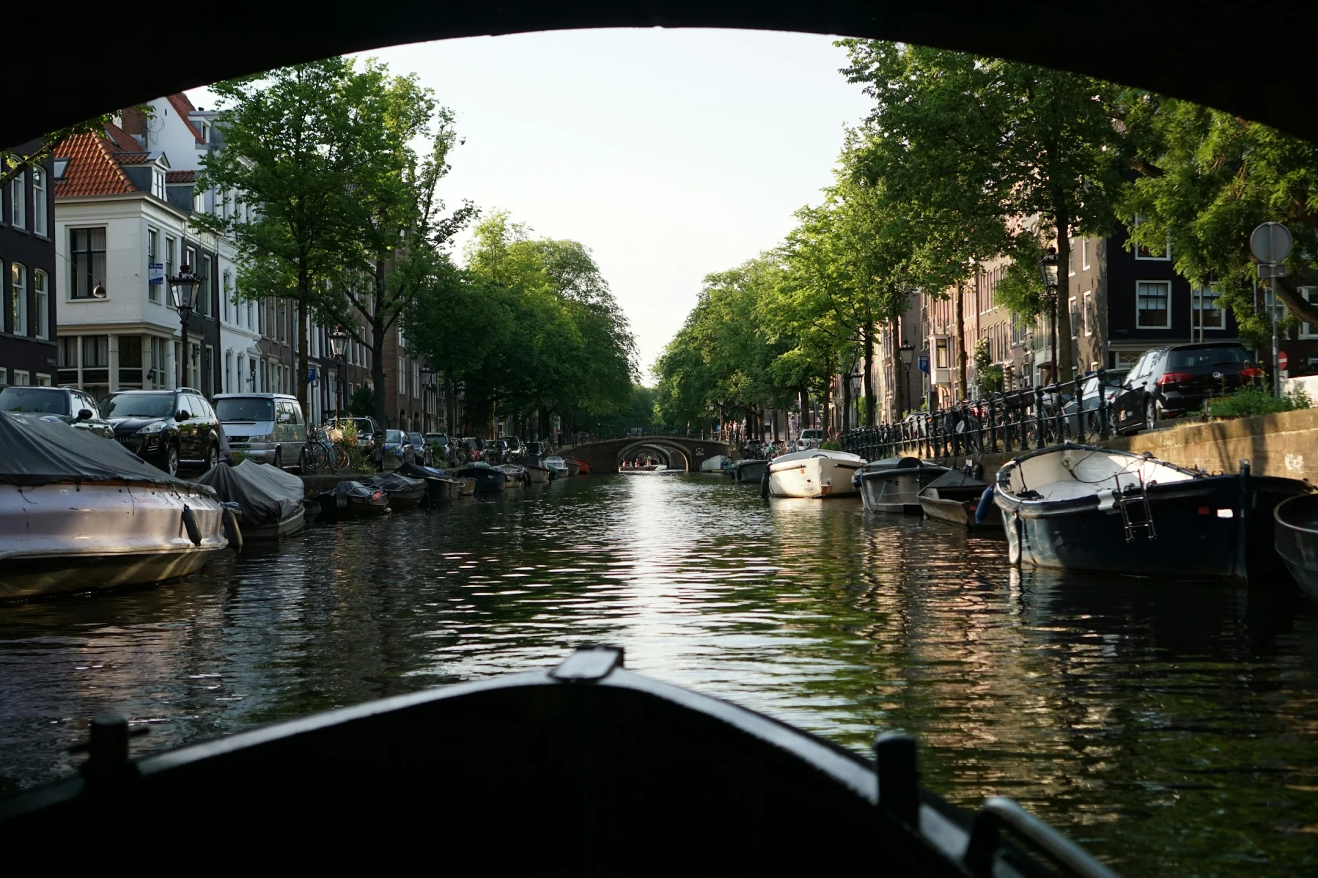 A canal cruise boat passing beneath a bridge
