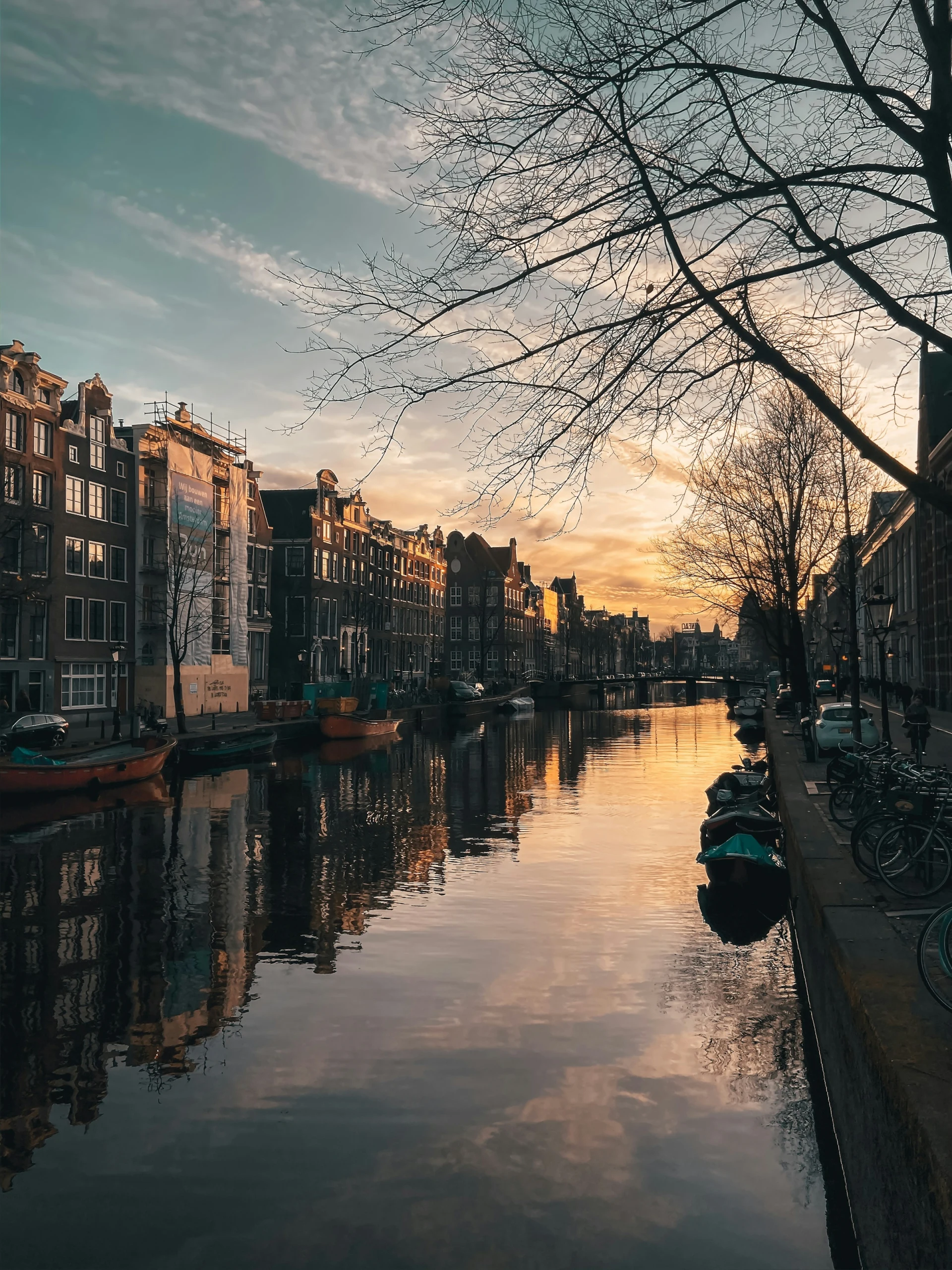Amsterdam canal houses reflected in the water at sunset