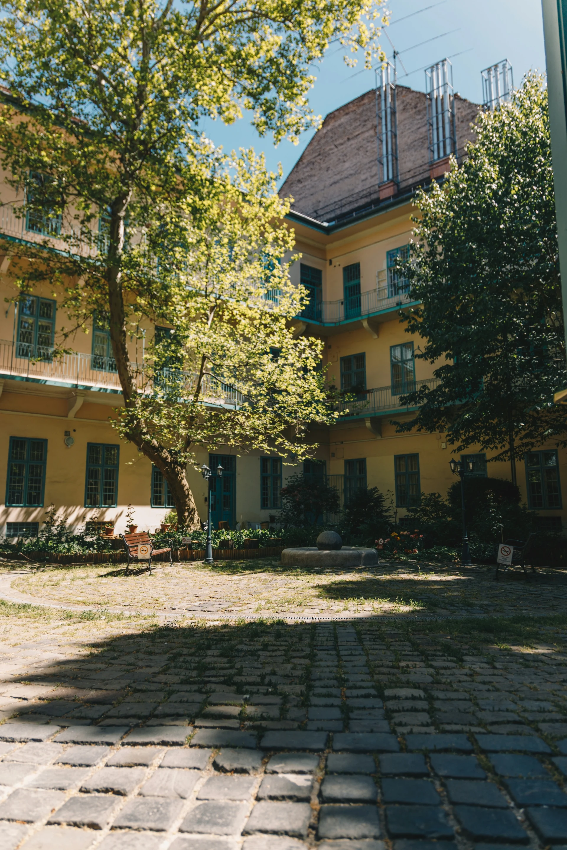 A quiet, tree-shaded courtyard tucked behind a historic building