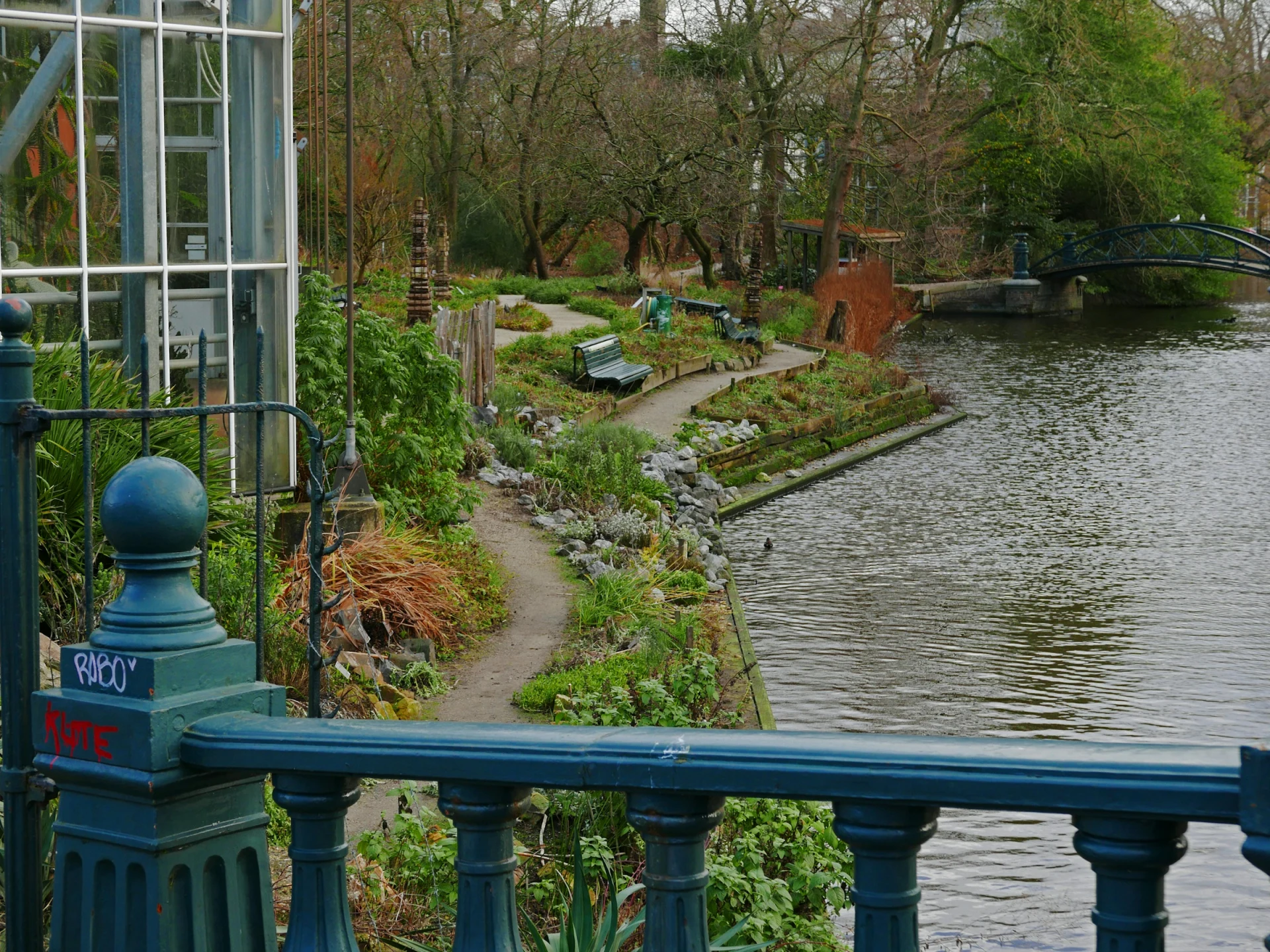A garden pond and bridge seen from a greenhouse