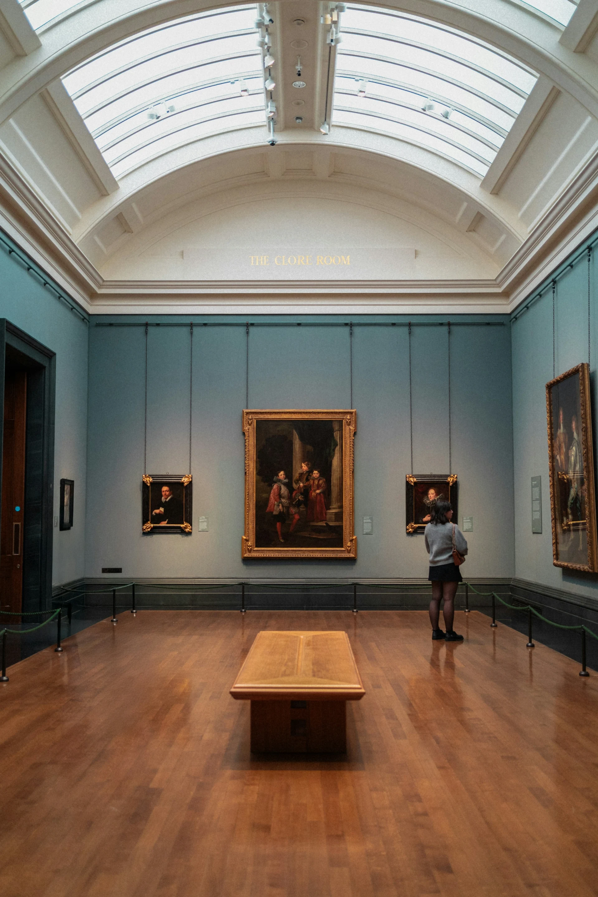 A visitor viewing a large painting in a museum gallery